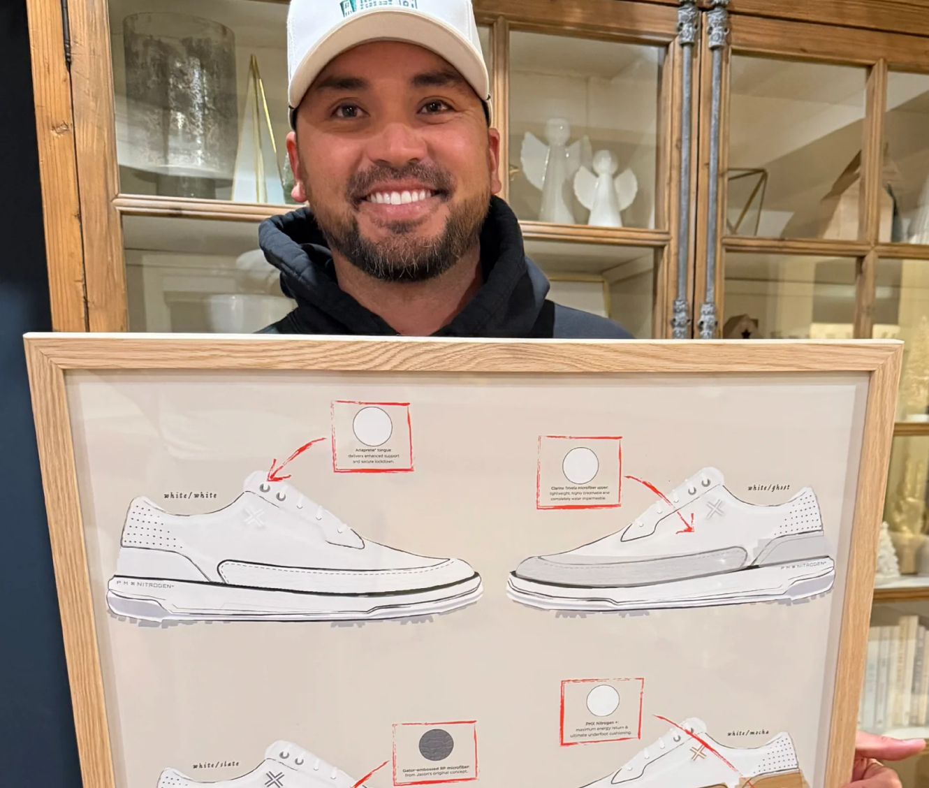 Jason Day holding a framed print of PAYNTR x Jason Day HYPE Collection shoe concept sketches