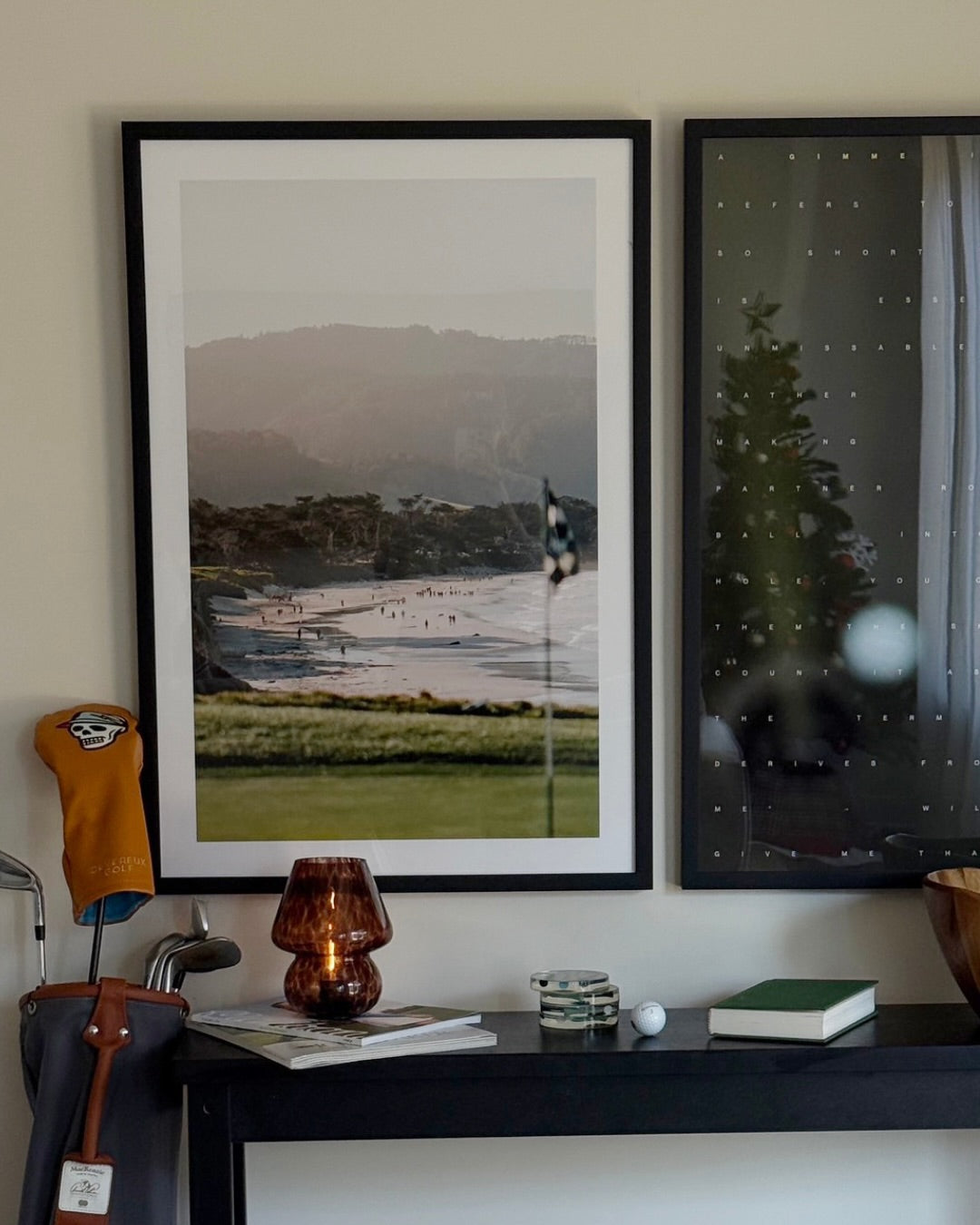 A woman posing next to a golf bag with a framed golf course photograph on the wall behind her