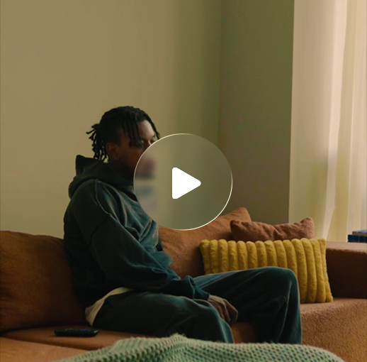 A person sitting quietly on a couch in a sunlit living room