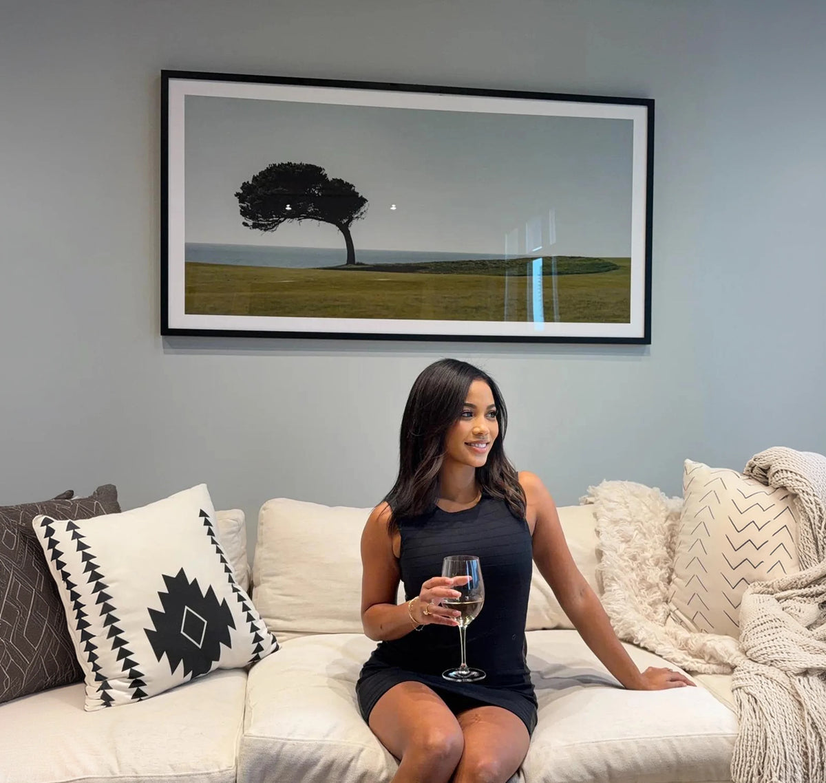 Framed golf art print displayed above a living room couch
