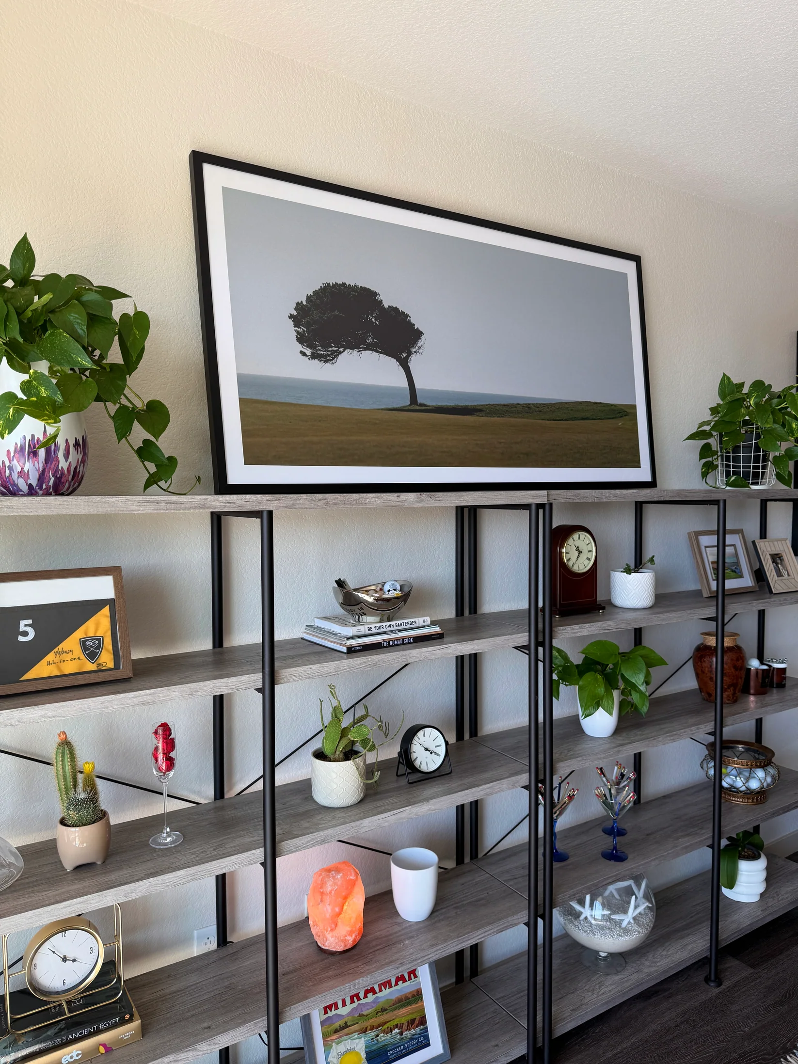 A large framed golf course photograph hanging in a living room